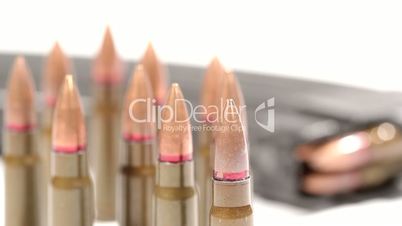 AK-47 ammunition. Defocus from a bunch of upright bullets in the front to a laying full magazine in the back.