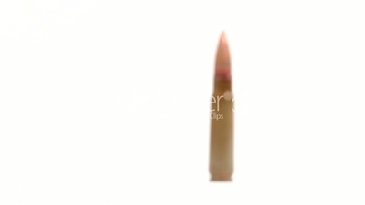AK-47 ammunition. Defocus from the foreground on a single upright bullet. White background.