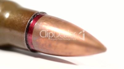 AK-47 ammunition. Defocus on a lying single bullet head. From the back to the front. White background.
