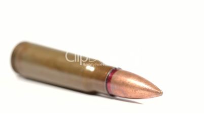 AK-47 ammunition. Defocus on a lying single bullet. From the front to the back. White background.