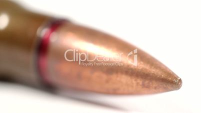 AK-47 ammunition. Defocus on a lying single bullet head. From the front to the back. White background.