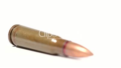 AK-47 ammunition. Defocus on a lying single bullet. From the back to the front. White background.