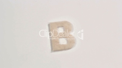 Felt letter “B” on white background. Defocus.