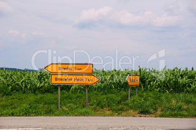 Schilder vor einem Maisfeld