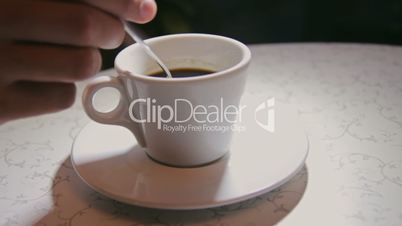 Man stirring coffee, close-up, shallow DOF