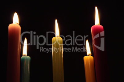 Fünf strahlende Kerzen vor schwarzem Hintergrund