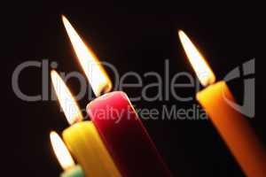 Vier strahlende Kerzen vor schwarzem Hintergrund