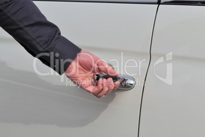 Mann öffnet mit linker Hand und Schlüssel eine Autotür