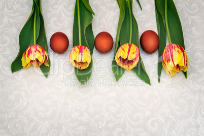 Three Easter eggs and tulips.