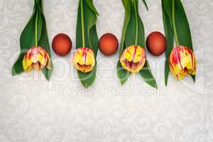 Three Easter eggs and tulips.