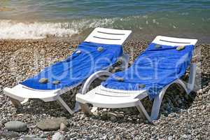 Two sun loungers for relaxing by the sea.