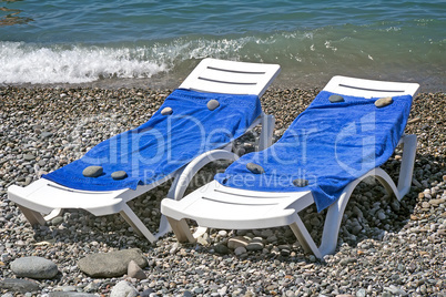 Two sun loungers for relaxing by the sea.