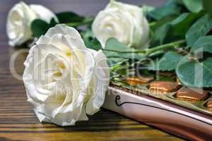White roses and chocolates as a gift.