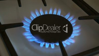 One gas burners burn blue flame on a gas stove