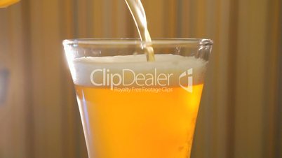Jet of light beer fills in a beer mug on the table