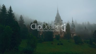 Peles Castle and a Misty Pine Tree Forest in Sinaia, Transylvania, Romania - Wide East View