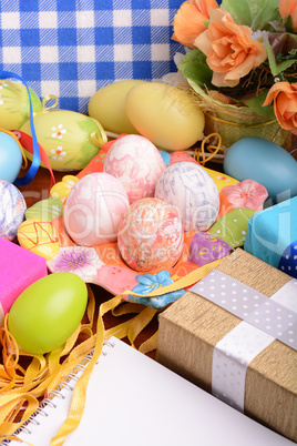 Easter background with colorful eggs and yellow tulips over white wood. Top view with copy space