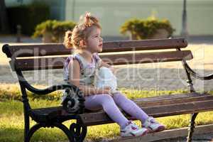 little girl sitting on the bench