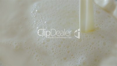 Ultra Slow Motion Shot of Milk Being Poured Over a Large Container