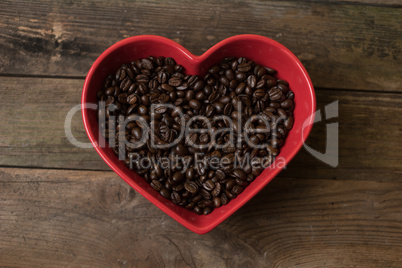 Coffee beans background and in the heart shaped bowl