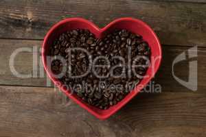 Coffee beans background and in the heart shaped bowl