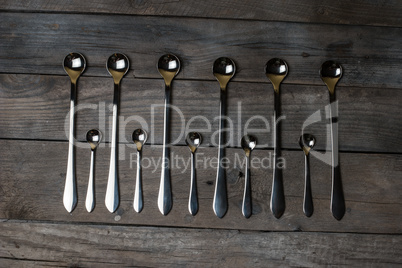 silver spoons arranged on the wood