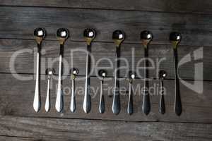 silver spoons arranged on the wood