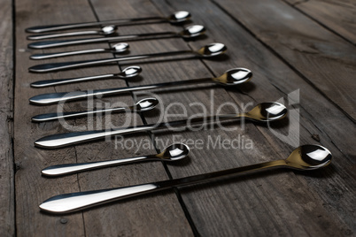 silver spoons arranged on the wood