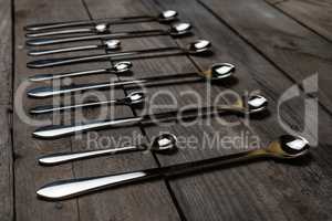 silver spoons arranged on the wood