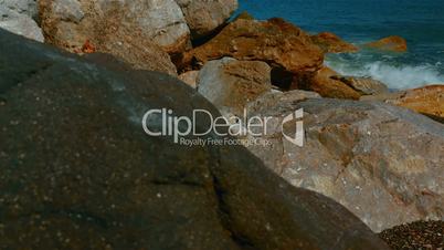 Slider Shot of Mediterranean Volcanic Beach with Black Sand and Red Rocks