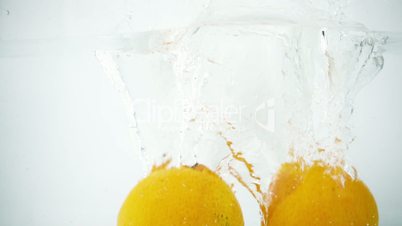 Two Tangerines Being Splashed into Water in Super Slow Motion