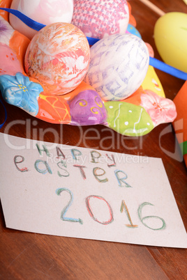 Easter with eggs in nest and yellow tulips over blue wooden table. Top view