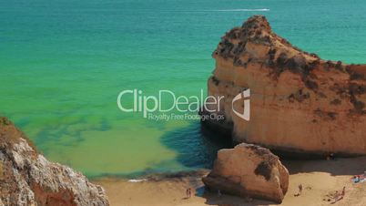 Static Shot of a Rocky Beach with Tourists in the Algarve, Portugal