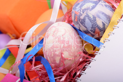 Arrangement of Gift Boxes in Wrapping Paper with Checkered Ribbons and Decorated Easter Eggs isolated on white background