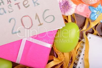 Easter background with colorful eggs and yellow tulips over white wood. Top view with copy space