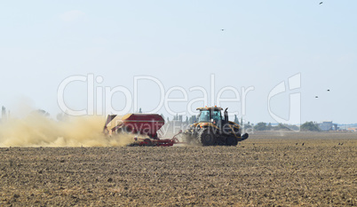 Tractor rides on the field and makes the fertilizer into the soil. Fertilizers after plowing the field.