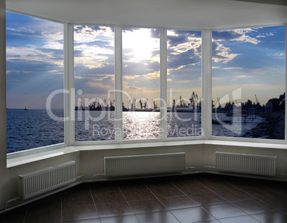 window with view of evening sea port docks and cranes