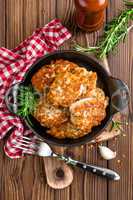 meat cutlets in frying pan on wooden rustic table