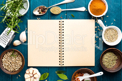 culinary background and recipe book with various spices on wooden table