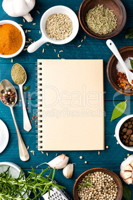 culinary background and recipe book with various spices on wooden table