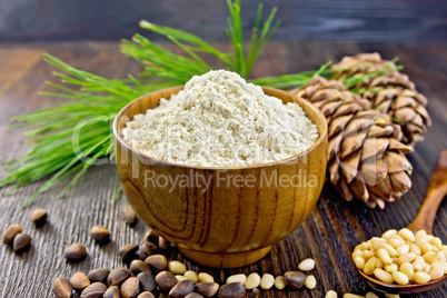 Flour cedar in bowl with nuts on wooden board