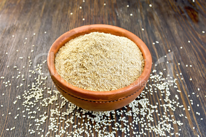 Flour sesame in clay bowl on board