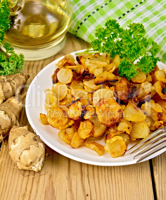 Jerusalem artichokes fried in dish with napkin on board