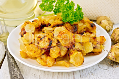 Jerusalem artichokes fried in plate on light board