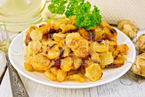 Jerusalem artichokes fried in plate on light board
