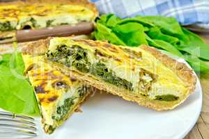 Pie with spinach and cheese in plate on board