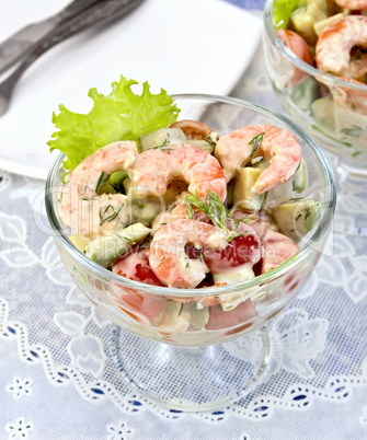 Salad with shrimp and tomatoes in glass on table