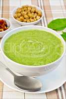 Soup puree with spinach and croutons on fabric