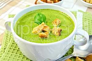 Soup puree with spinach and spoon on a napkin