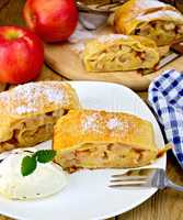 Strudel with apples and ice cream with napkin on board
